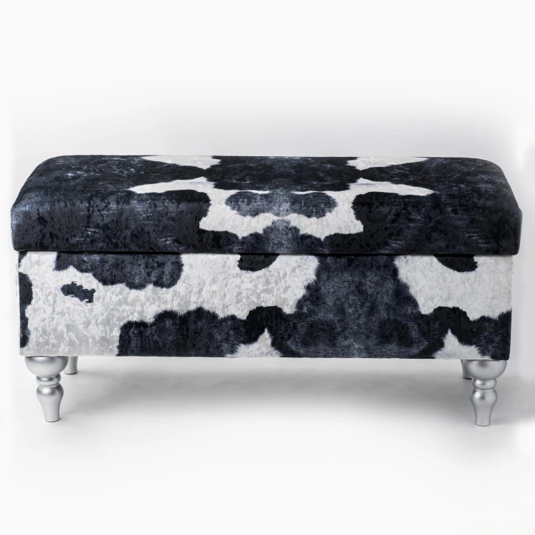 Storage pouffe with cow pattern upholstery