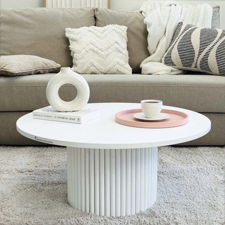 Round white coffee table with decorative grooved leg for bright, spacious interiors