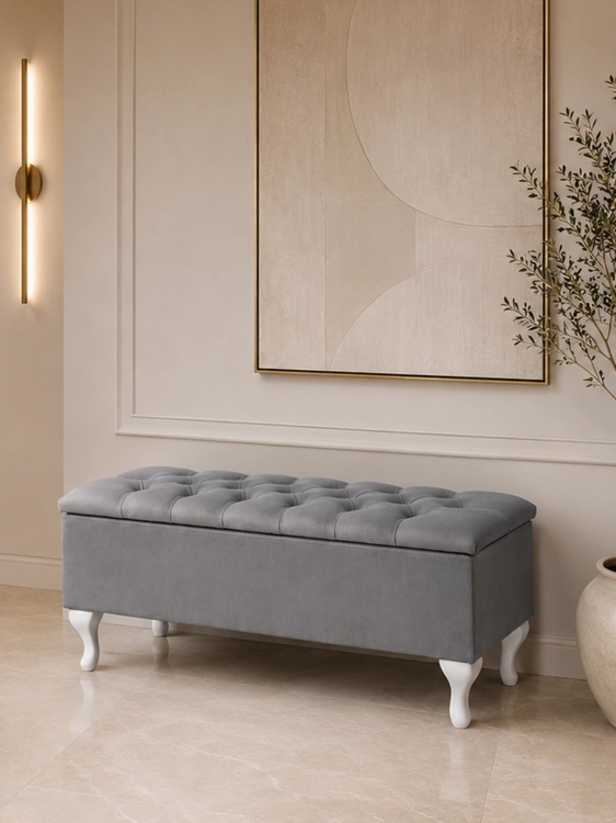 A quilted trunk with a seat, set on white legs ideal for the hallway.