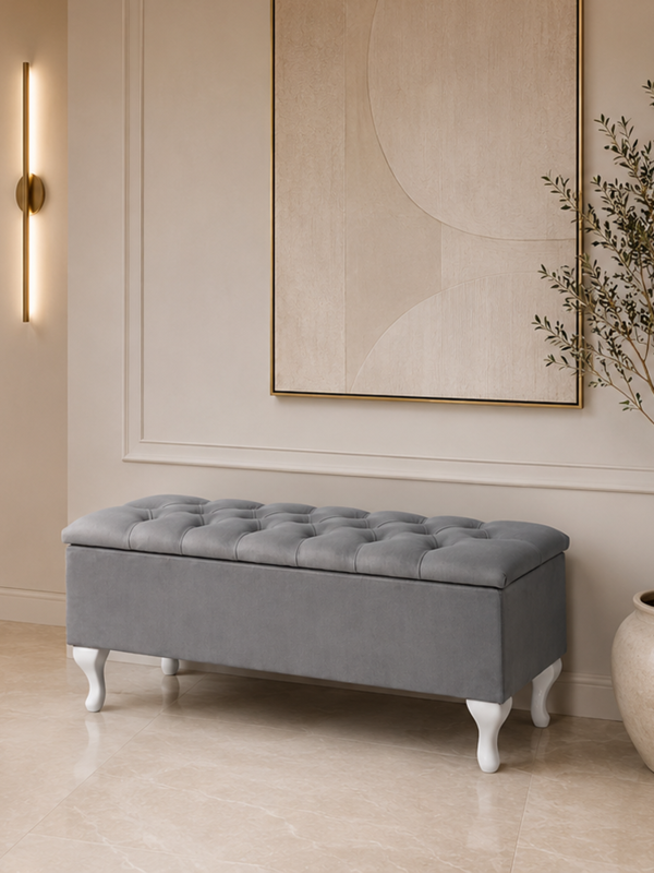 A quilted trunk with a seat, set on white legs ideal for the hallway.