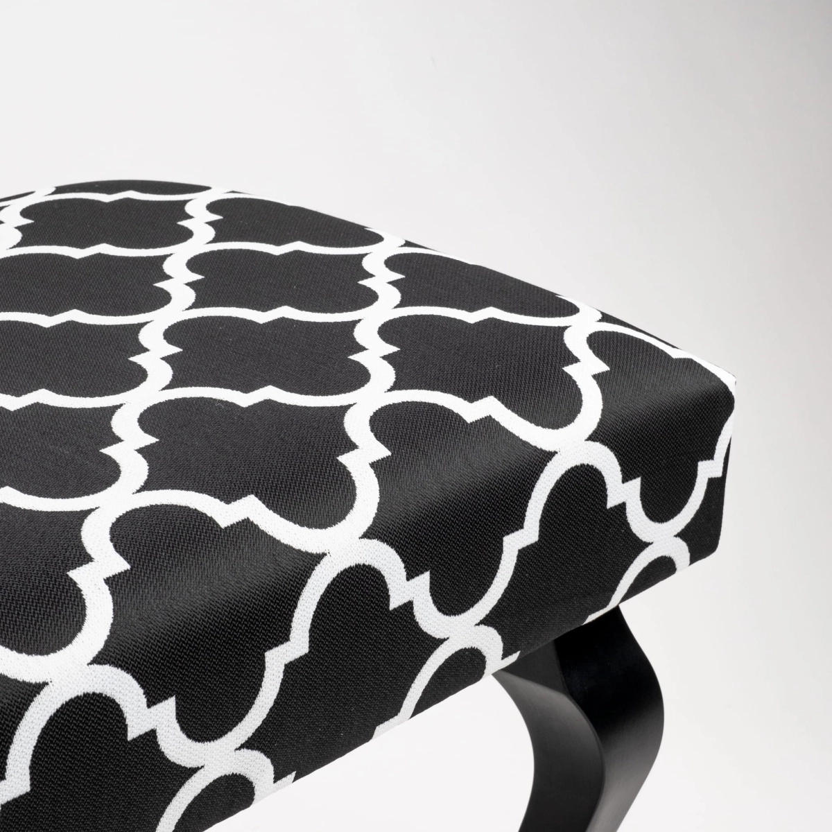 Decorative bench with ornate upholstery and black legs