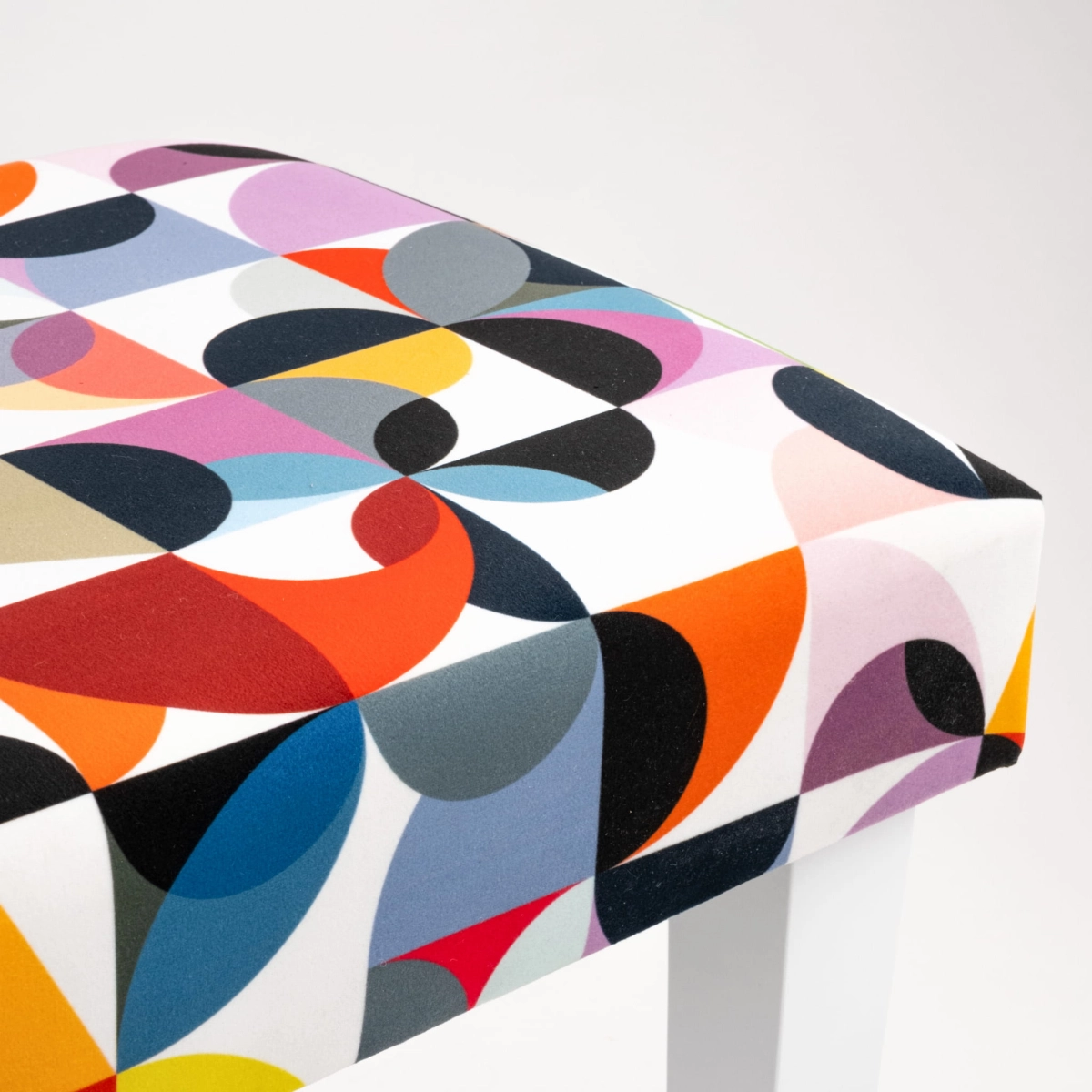 Patterned upholstered bench with white legs