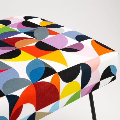 Upholstered bench with colorful patterns and pin-shaped legs