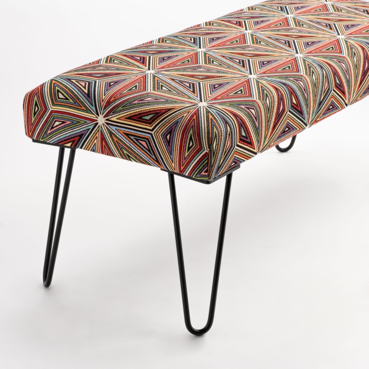 Upholstered patterned bench on metal legs, perfect for industrial interiors