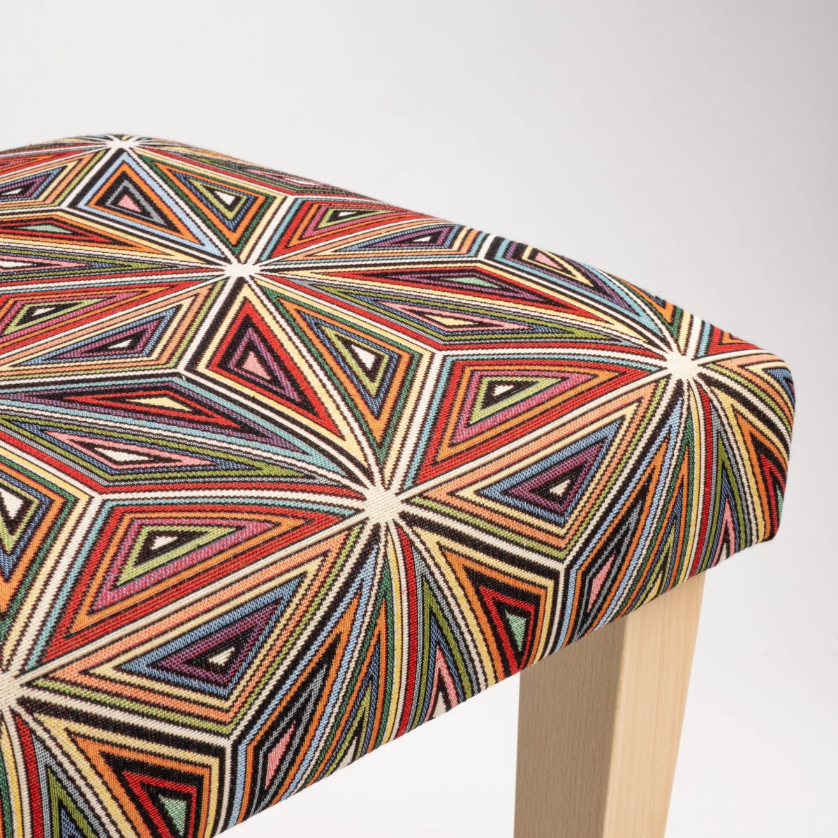 Upholstered patterned bench on wooden legs