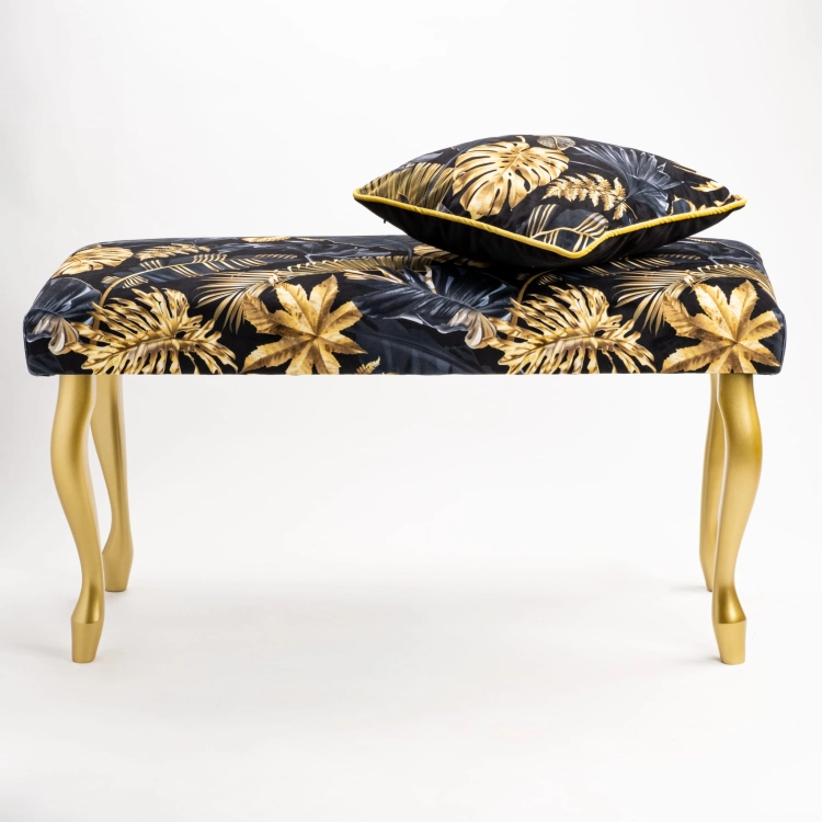 Upholstered bench with gold patterns and legs