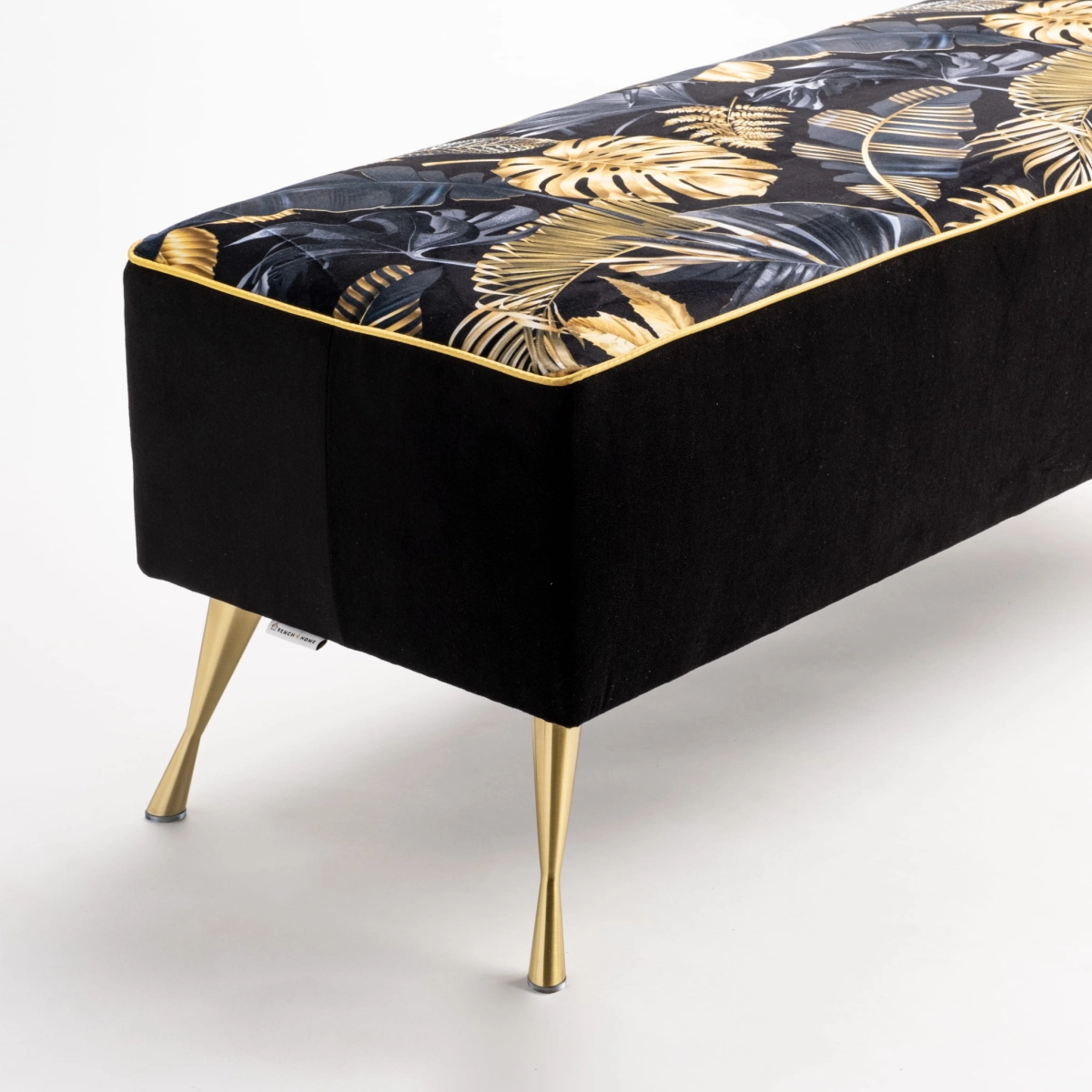 Upholstered bench with gold patterns and metal legs