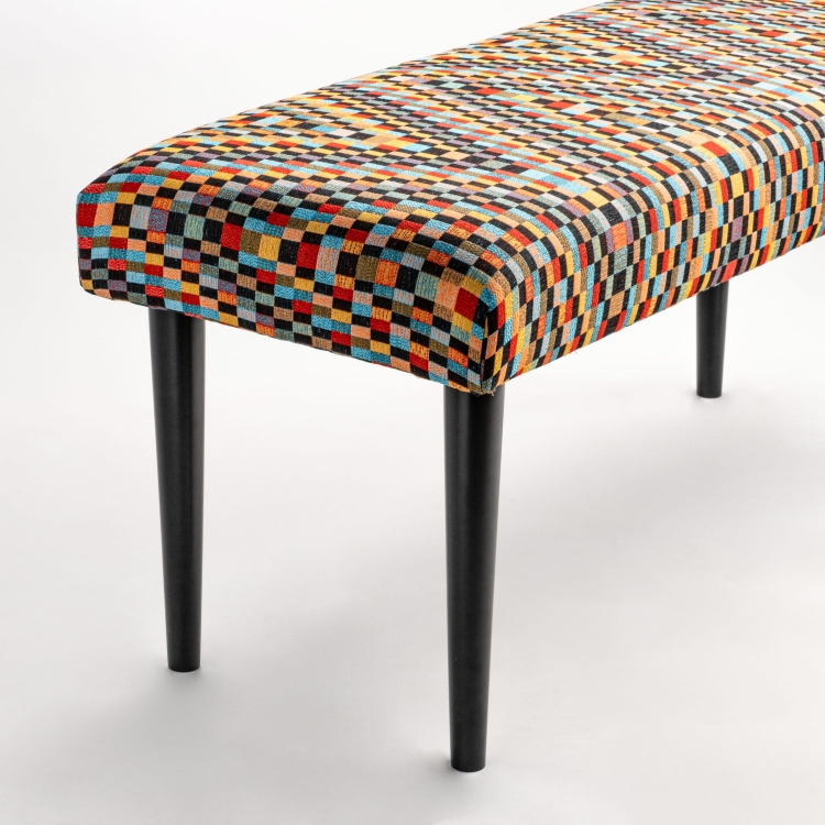 Upholstered bench with black legs and patterned fabric