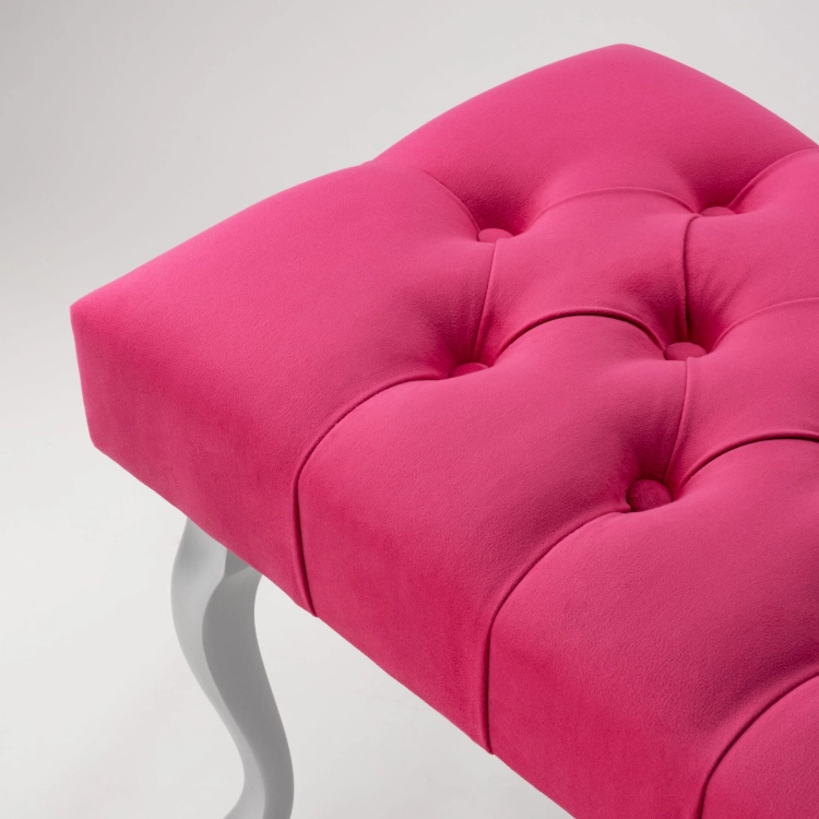 Stylish fuchsia tufted bench with silver metal legs, perfect for a living room or dressing room