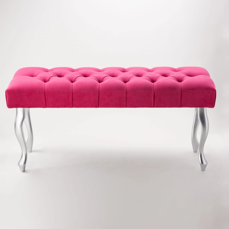 An elegant, quilted bench in an intense fuchsia color with silver legs.