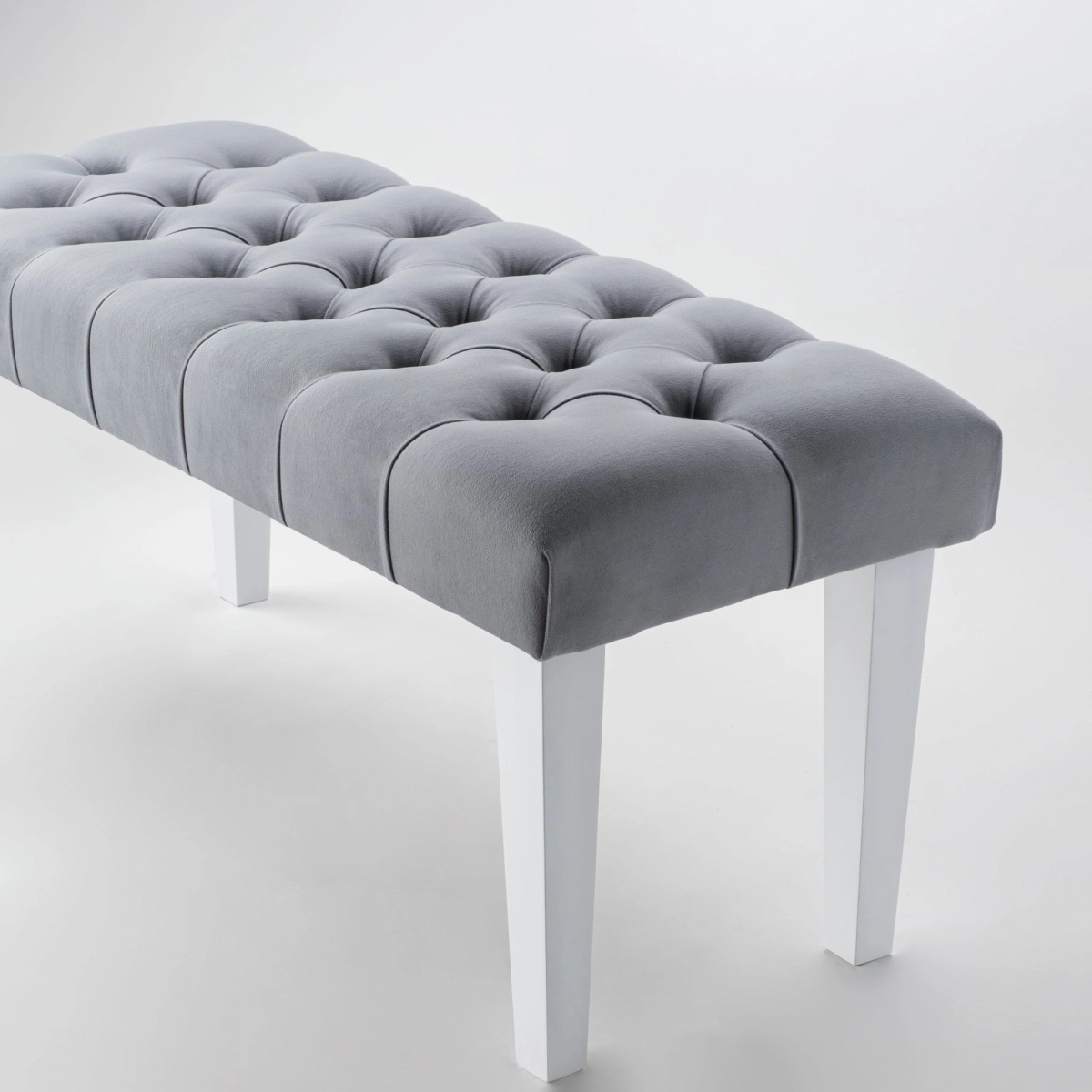 Stylish bench in grey with quilted upholstery and white legs