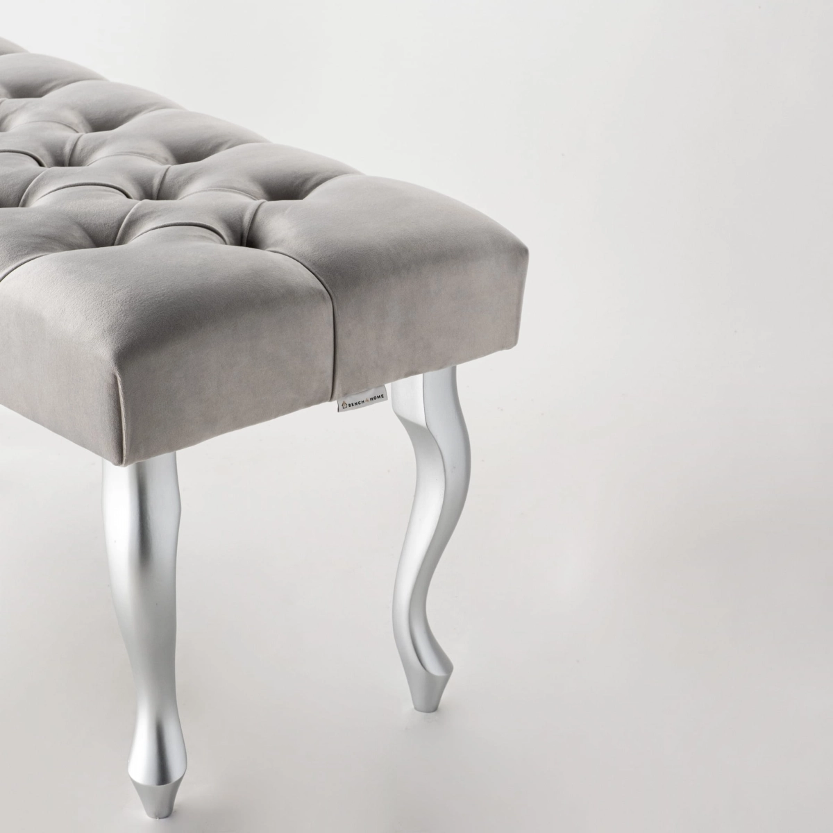 Gray upholstered bench with silver metal legs