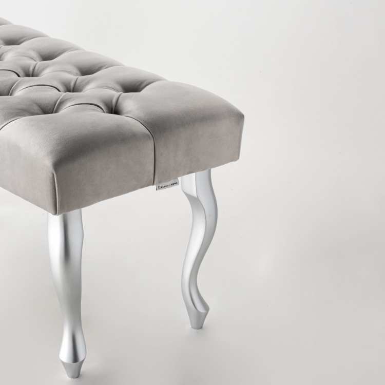 Gray upholstered bench with silver metal legs