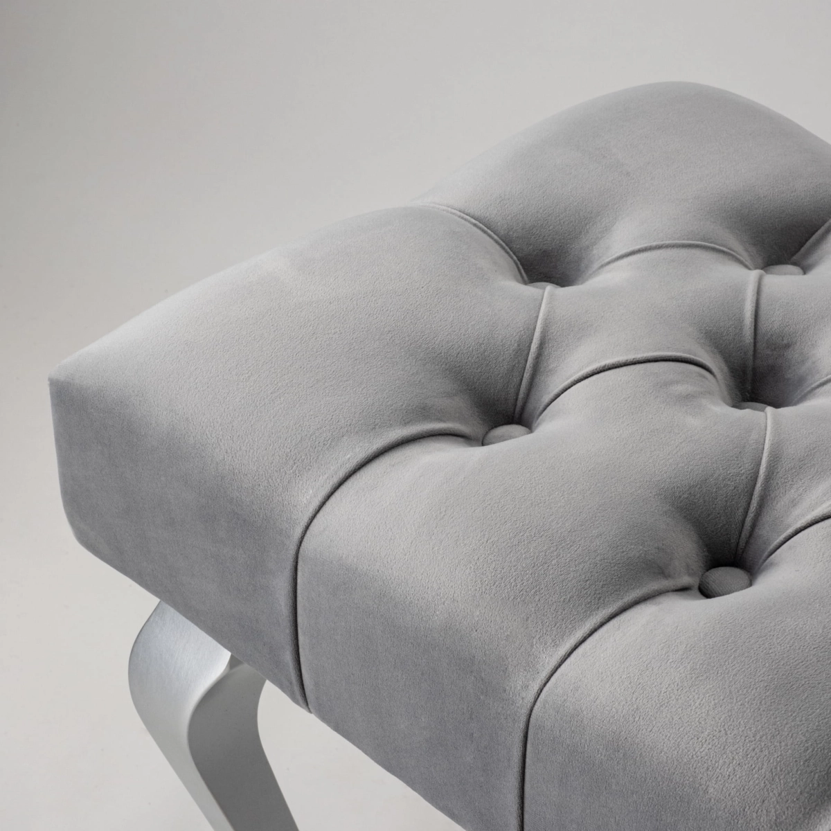 Gray quilted bench with shiny chrome legs