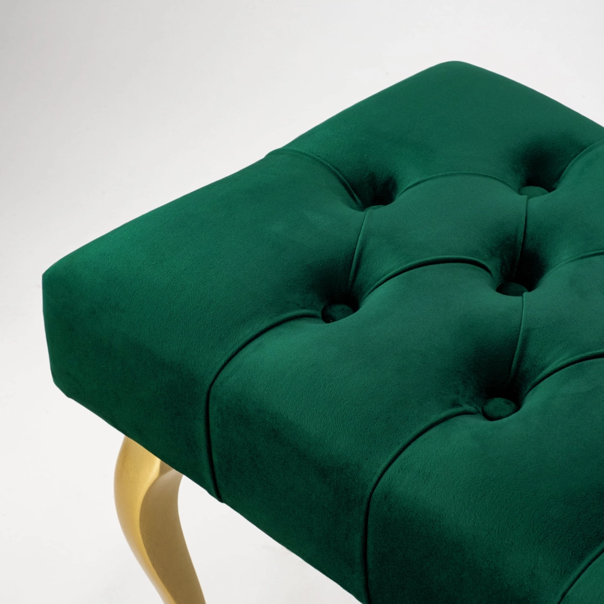 Elegant quilted bench with golden legs in bottle green