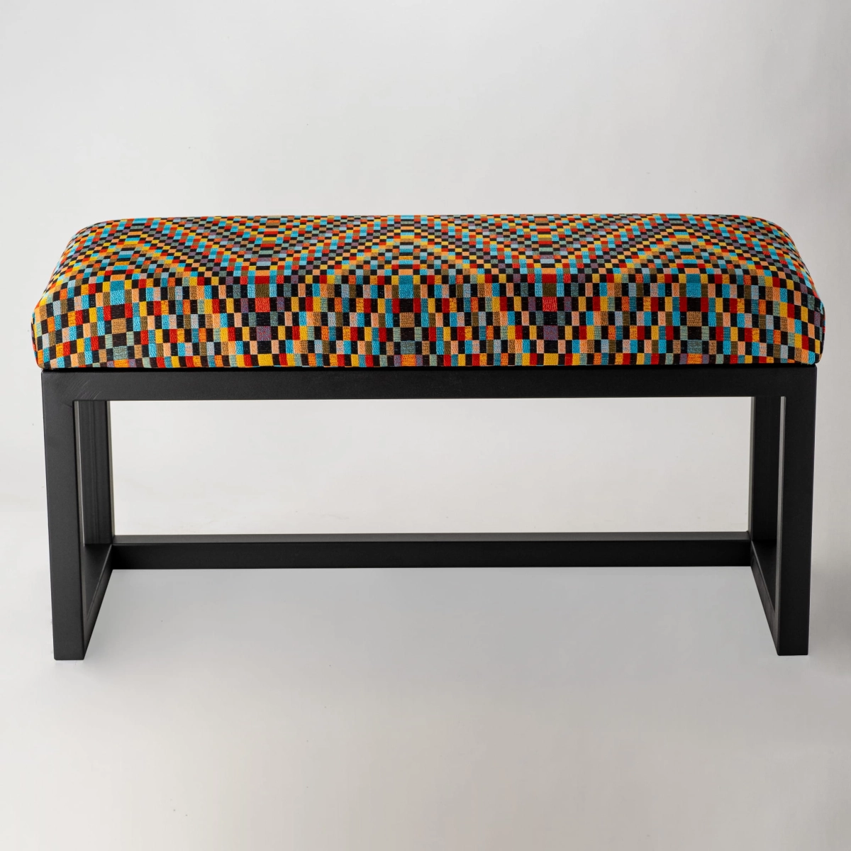 Patterned upholstered bench on metal legs, ideal for loft interiors